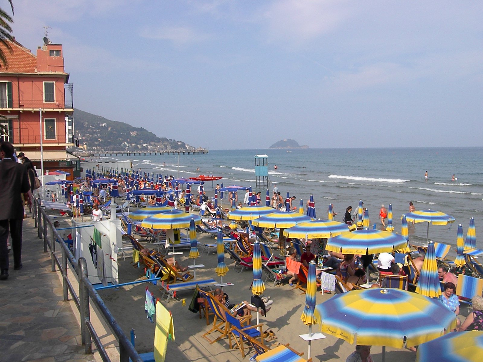 Küstenpromenade mit dichtem Strand und bunten Sonnenschirmen am Mittelmeer