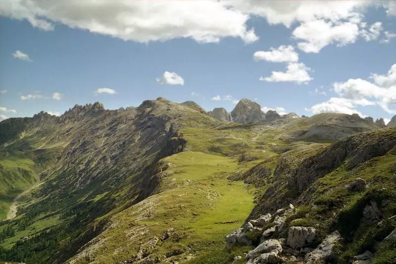 Grüne Hochfläche und felsige Gipfel im Alpenraum