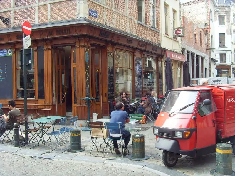 Straßencafé mit Gästen in einer Brüsseler Altstadtstraße
